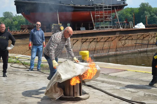 Gaszenie płonącego pojemnika kocem gaśniczym