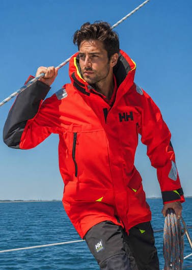 Żeglarz w czerwonej kurtce sztormowej Helly Hansen na pokładzie jachtu